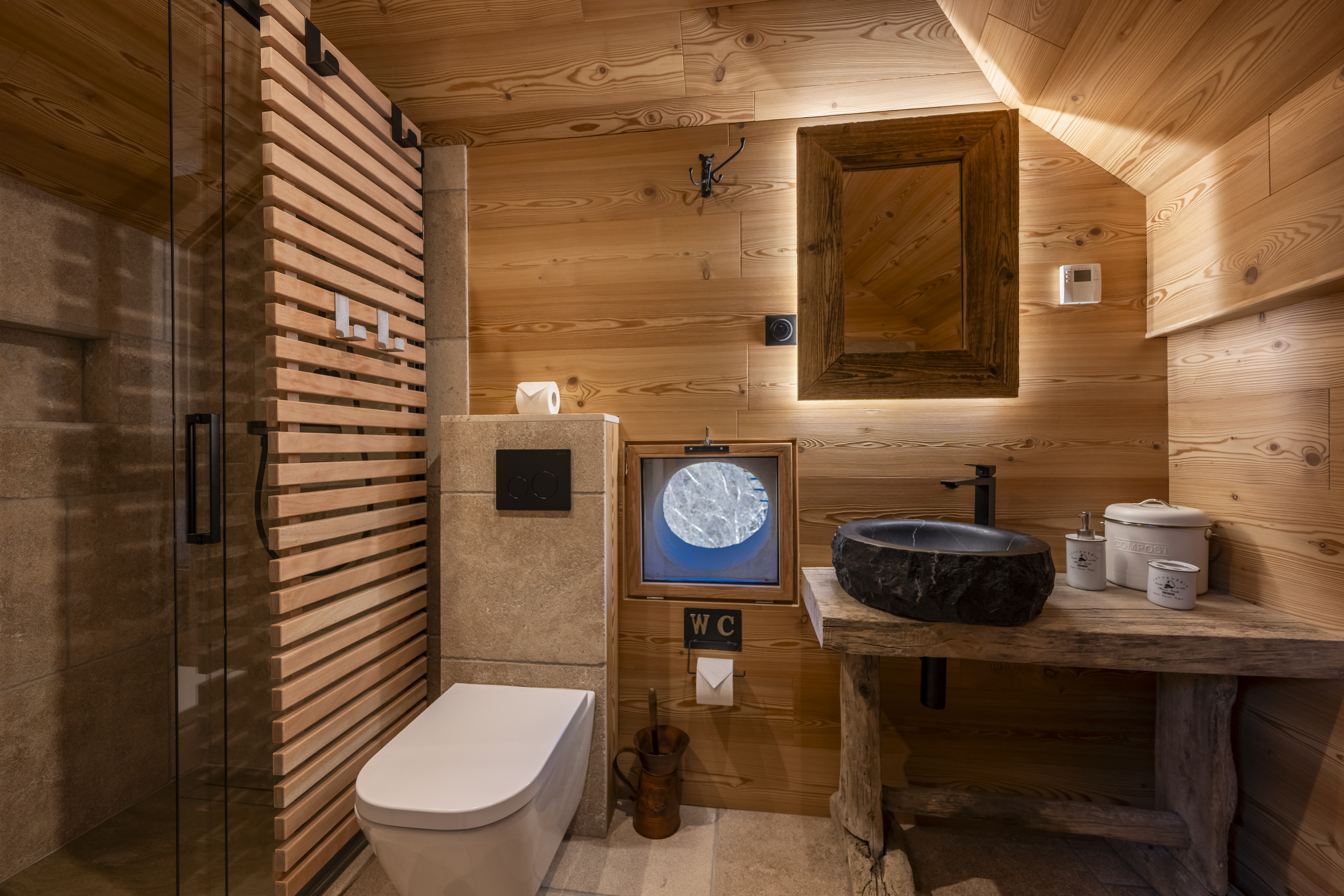 Salle de bain chalet Enchastraye, ambiance montagne, bois naturel, pierre, design alpin, confort.