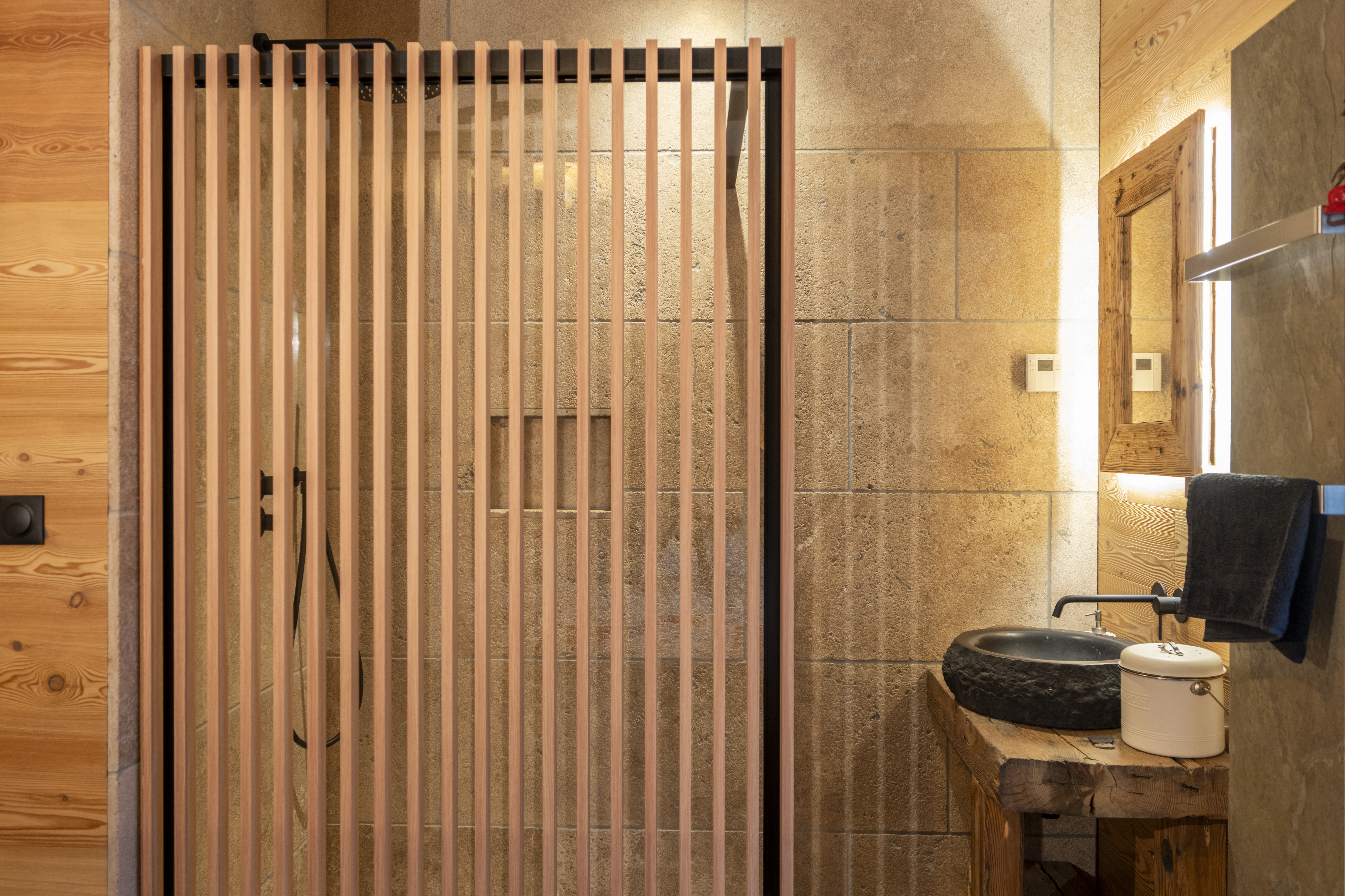 Salle de bain de chalet à Enchastraye, style montagnard, matériaux naturels, bois, pierre, élégance.